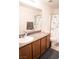 Well-lit bathroom with a granite countertop vanity and a shower featuring a stylish leafy green shower curtain at 4178 Eagle Island St, Las Vegas, NV 89130