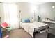 Bright bedroom featuring a metal bed frame, a small chair, and a writing desk at 4178 Eagle Island St, Las Vegas, NV 89130