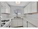 Bright kitchen features white cabinets, modern countertops, stainless steel sink and white appliances at 4400 W Lake Mead Blvd # 101, Las Vegas, NV 89108