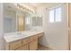 Bright bathroom featuring a large mirror, vanity with sink, and natural light from the window at 5249 Wave Dancer Ln, Las Vegas, NV 89118