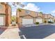 Exterior shot of a row of two-story townhomes featuring attached garages and desert landscaping at 5249 Wave Dancer Ln, Las Vegas, NV 89118