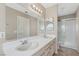Bathroom with double sink vanity, large mirror, updated lighting, and a walk-in shower at 5636 Royal Castle Ln, Las Vegas, NV 89130