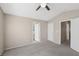 Spacious bedroom featuring neutral walls, gray carpet, and doorways leading to an ensuite and hall at 5636 Royal Castle Ln, Las Vegas, NV 89130