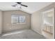 Bedroom features neutral walls, gray carpet, a ceiling fan, and an ensuite bathroom at 5636 Royal Castle Ln, Las Vegas, NV 89130