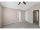 Spacious bedroom featuring neutral walls, gray carpet, and doorways leading to an ensuite and hall at 5636 Royal Castle Ln, Las Vegas, NV 89130