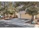 Charming beige two-story home featuring a two-car garage, driveway, and mature landscaping at 5636 Royal Castle Ln, Las Vegas, NV 89130