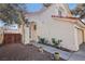 Beige two-story home with a red tile roof, arched entryway, desert landscaping, and a two-car garage at 5636 Royal Castle Ln, Las Vegas, NV 89130