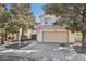 A charming beige two-story home with a two-car garage and desert landscaping including shade trees at 5636 Royal Castle Ln, Las Vegas, NV 89130