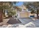 A charming beige two-story home with a two-car garage, desert landscaping, and gated side yard at 5636 Royal Castle Ln, Las Vegas, NV 89130