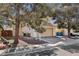 A charming beige two-story home with a two-car garage, desert landscaping, and plenty of curb appeal at 5636 Royal Castle Ln, Las Vegas, NV 89130