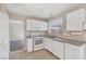 Bright kitchen featuring white cabinets, appliances, and tile flooring at 5636 Royal Castle Ln, Las Vegas, NV 89130