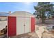 Exterior view of the red and white storage shed in the backyard with a stepping stone path at 5636 Royal Castle Ln, Las Vegas, NV 89130