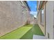 Narrow backyard featuring artificial turf and a gate for added privacy and access at 5717 Heineken Dr, North Las Vegas, NV 89031
