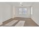 Spacious bedroom featuring neutral walls, ceiling fan, carpeted floor and bright, natural light from two windows at 5717 Heineken Dr, North Las Vegas, NV 89031