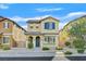 Charming two-story home with desert landscaping, blue door and shutter accents under a beautiful sunny sky at 5717 Heineken Dr, North Las Vegas, NV 89031