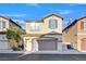 Charming two-story home featuring a neutral color palette, two-car garage, and well-maintained landscaping at 5717 Heineken Dr, North Las Vegas, NV 89031