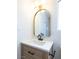 Stylish bathroom with a wood vanity, quartz countertop, modern fixtures, and an arched mirror at 6170 W University Ave, Las Vegas, NV 89103