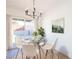 Bright dining room with modern chandelier, glass table, and seating for four at 6170 W University Ave, Las Vegas, NV 89103