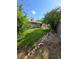 Backyard with mature trees, grass, desert landscaping, and covered patio at 6284 Explorer Dr, Las Vegas, NV 89103