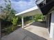Covered patio and landscaped backyard featuring grassy area and privacy landscaping at 6284 Explorer Dr, Las Vegas, NV 89103