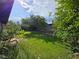 Backyard featuring green grass, mature trees, plants, and privacy fence at 6284 Explorer Dr, Las Vegas, NV 89103