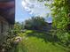 Backyard with grass, mature trees, desert landscaping, and privacy fence at 6284 Explorer Dr, Las Vegas, NV 89103