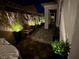 Charming backyard with brick pavers, bench seating, and illuminated plants for a tranquil outdoor space at 704 Webber Park St, Henderson, NV 89011