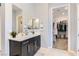 Contemporary bathroom features a dark vanity with double mirrors and a walk-in closet at 704 Webber Park St, Henderson, NV 89011