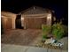 Home featuring a spacious two-car garage with brick paver driveway and decorative landscaping at 704 Webber Park St, Henderson, NV 89011