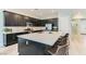 Modern kitchen with sleek black cabinetry, a large center island, stainless steel appliances, and stylish countertops at 704 Webber Park St, Henderson, NV 89011