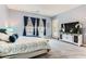 A main bedroom featuring a queen size bed and a large wall-mounted television at 704 Webber Park St, Henderson, NV 89011