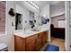 Bathroom with dual sinks and wood cabinets, offering functionality and style at 7120 Bear Paw Creek St # 101, Las Vegas, NV 89149