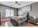 Cozy bedroom with wood-look floors, soft rug, ceiling fan, and large windows at 7120 Bear Paw Creek St # 101, Las Vegas, NV 89149
