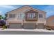 Three-story townhome with three-car garage featuring desert landscaping and stone accents at 7120 Bear Paw Creek St # 101, Las Vegas, NV 89149