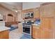 Charming kitchen featuring stainless steel appliances, wood cabinets, and modern backsplash at 7120 Bear Paw Creek St # 101, Las Vegas, NV 89149