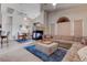 Open-concept living room with a unique fireplace, vaulted ceilings, and a comfortable sectional couch at 7120 Bear Paw Creek St # 101, Las Vegas, NV 89149