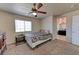 Bedroom features a ceiling fan, neutral walls and carpet, bright window, and ensuite access at 7137 Eyebright St, Las Vegas, NV 89131