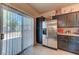 Bright kitchen featuring modern appliances, dark cabinetry, and access to the outdoor patio at 7137 Eyebright St, Las Vegas, NV 89131