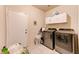 Laundry room features modern washer and dryer, with ample storage cabinets, and tile floor, providing convenience at 7137 Eyebright St, Las Vegas, NV 89131