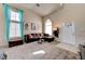 Bright living room with carpet, large windows, stylish decor, and access to a front door, creating an inviting and comfortable space at 7137 Eyebright St, Las Vegas, NV 89131