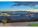Las Vegas skyline view from backyard with desert landscaping, turf and wrought iron fencing at 743 N Orleans St, Henderson, NV 89015