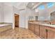 Luxury bathroom with dual sinks, granite counters, large tub, and travertine floors at 743 N Orleans St, Henderson, NV 89015