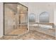 Bathroom featuring marble floors, a jetted tub, and a luxurious glass-enclosed shower at 743 N Orleans St, Henderson, NV 89015