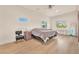 A bright bedroom featuring wood-look floors, ceiling fan, and natural light from several windows at 743 N Orleans St, Henderson, NV 89015