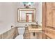 Stylish powder room with a unique vessel sink, decorative mirror, and stone accents at 743 N Orleans St, Henderson, NV 89015
