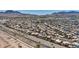 A wide aerial view of a residential neighborhood, train tracks, desert landscaping, and mountain views at 818 Grape Vine Ave, Henderson, NV 89002