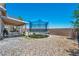 The backyard features a trampoline, covered patio with furniture, and rock landscaping at 818 Grape Vine Ave, Henderson, NV 89002