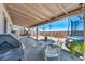 Covered backyard patio with outdoor seating, a grill, and drought resistant landscape at 818 Grape Vine Ave, Henderson, NV 89002