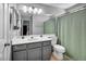 Bathroom with single vanity, toilet and shower behind a green curtain at 818 Grape Vine Ave, Henderson, NV 89002