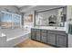 Bright bathroom featuring a double vanity, soaking tub, and large window at 818 Grape Vine Ave, Henderson, NV 89002